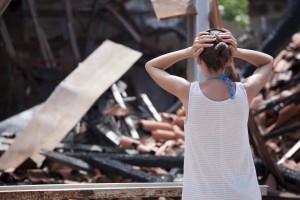 Woman in front of burned out house